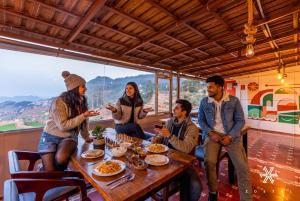 a group of people sitting around a table at Zostel Ooty, Pudumund in Ooty