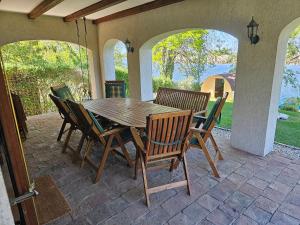 a wooden table and chairs on a patio at Waterside Cottage in Nagyrév