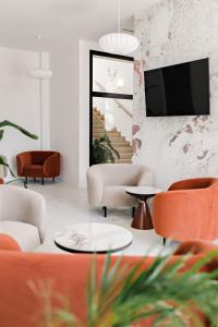 a living room with orange and white furniture and a tv at Park Hotel Żywiec in Żywiec