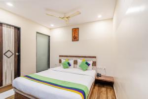 a bedroom with a large white bed with green pillows at Treebo Address Inn, Banjara Hills in Hyderabad +33 photos