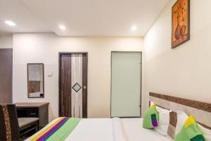 a bedroom with a bed and a desk and a chair at Treebo Address Inn, Banjara Hills in Hyderabad