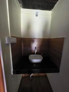 a small bathroom with a sink in a room at Shanti Niketan in Kārwār