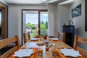 a dining room with a wooden table and a large window at Au doux passage in Les Rousses