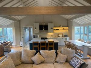 a living room with a couch and a kitchen at The Annexe, Cleveley Mill in Chipping Norton +12 photos