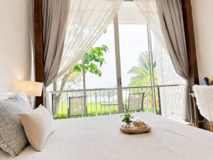 ein Schlafzimmer mit einem Bett und einem großen Fenster in der Unterkunft White Wall Riverfront Hotel in Kamphaeng Phet