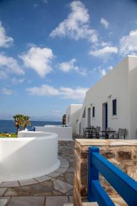 a view of a white building with a blue fence at Aura Paros in Logaras