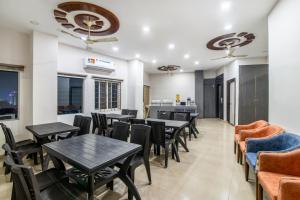 a restaurant with tables and chairs and a bar at Treebo Address Inn, Banjara Hills in Hyderabad