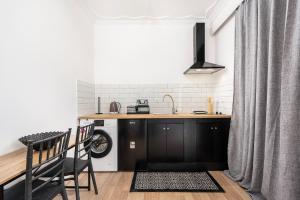 a kitchen with black cabinets and a sink at Topfix Luxury Home 2 in Kos