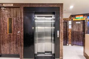 a metal elevator in a building with wooden walls at Treebo Address Inn, Banjara Hills in Hyderabad