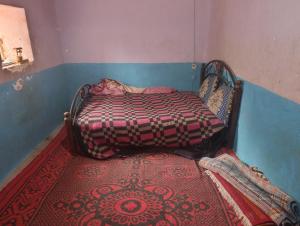a small bed in a room with a carpet at dar elkarzabi in Zagora +17 photos