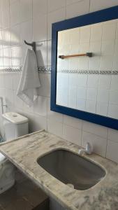 a bathroom with a sink and a mirror and a toilet at Santorini Suítes in Tamandaré +42 photos