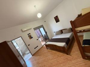 a bedroom with a bed and a mirror at Vila Emanuele in Shëngjin