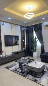 a living room with a couch and a table at Wenggies Apartment in Abuja