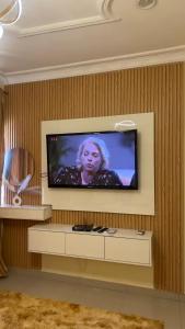 a flat screen tv on a wall in a room at Wenggies Apartment in Abuja +1 photo