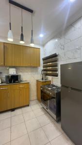 a kitchen with stainless steel appliances and wooden cabinets at Wenggies Apartment in Abuja