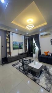 a living room with a couch and a tv at Wenggies Apartment in Abuja