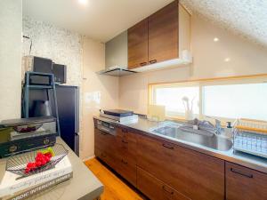 a kitchen with wooden cabinets and a sink and a window at Shirakaba in Otaru