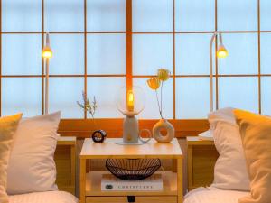 a room with two beds and a table with a lamp at Shirakaba in Otaru