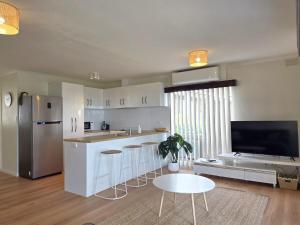 a kitchen with a table and chairs and a refrigerator at Milliana House in Wallaroo