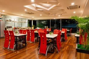 a restaurant with red chairs and tables in a room at INAP Melaka - Suites & Living in Malacca