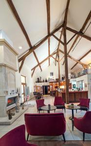 a large living room with tables and chairs and a fireplace at Logis Auberge Des Moissons in Matougues