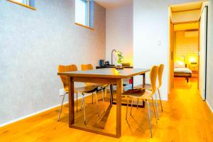 a dining room with a wooden table and chairs at Shirakaba in Otaru