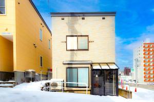 a building with a bus stop in the snow at Shirakaba in Otaru