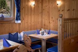 a dining room with a table and blue chairs at Hotel Gasthof Siggen in Neukirchen am Großvenediger