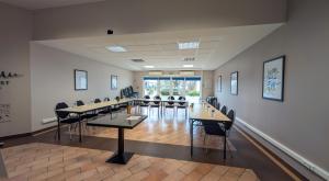 a large room with tables and chairs in it at Logis Auberge Des Moissons in Matougues