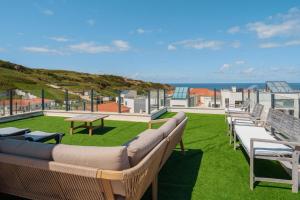 a row of benches sitting on top of a lawn at Paradise Villa Sky - Signature by Paradise Portugal in Ribamar +40 photos