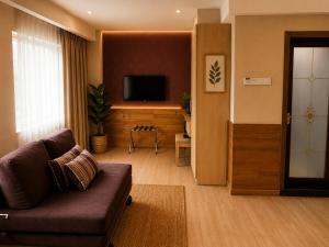 a living room with a couch and a flat screen tv at INAP Melaka - Suites & Living in Malacca