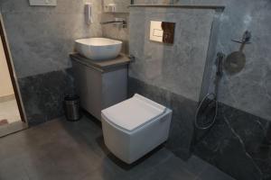 a bathroom with a toilet and a sink and a shower at Hotel Radha Vallabh in Ukhimath +39 photos