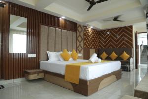a bedroom with a large white bed with yellow pillows at Hotel Radha Vallabh in Ukhimath