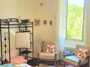 a living room with two chairs and a shelf with a mirror at La Chambre d'Artiste in Laguépie