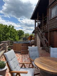 a patio with a table and chairs and a grill at Wood house Marilla in Virovitica