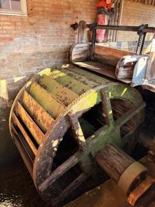 a large wooden wheel sitting next to a brick wall at BohnApartments Vogelmühle Ilsenburg in Ilsenburg