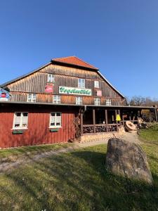 a large red barn with a rock in front of it at BohnApartments Vogelmühle Ilsenburg in Ilsenburg