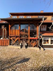 a wooden building with a large wheel in front of it at BohnApartments Vogelmühle Ilsenburg in Ilsenburg