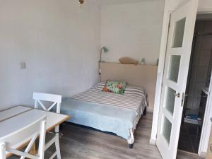 a small bedroom with a bed and a desk at Les Chalets la Plage - Etape Vacances in Portiragnes