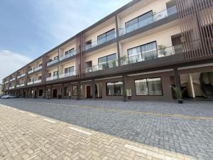 a large building with a parking lot in front of it at The Grand Avora Apartment With 3 Ac And Free Parking in Lahore