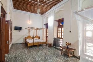a bedroom with a bed and a table in a room at MAKAPUS Stone Town Apartments in Zanzibar City