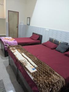 two beds in a room with red sheets at Hotel Badri Palace in Rishīkesh +16 photos