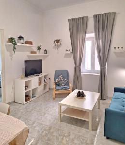 a living room with a blue couch and a tv at Marvelous flat in the city center in Ceuta