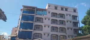 a tall white building with windows at The Folks Inn in Mombasa