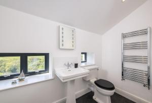a white bathroom with a sink and a toilet at Pentreath in Bude +39 photos