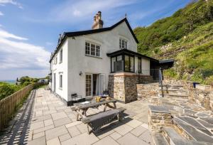 a white house with a picnic table in front of it at Pentreath in Bude