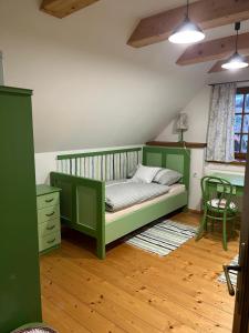 a bedroom with a green bed and a chair at Chalúpka Barborka in Lúčky