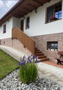 a house with a staircase and flowers in the yard at Chalúpka Barborka in Lúčky