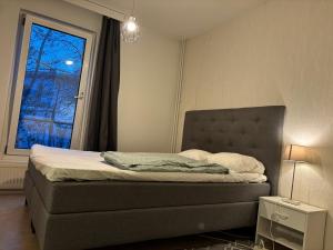 a bedroom with a bed with a window and a lamp at Cozy Apartment with Private Sauna in Vaasa