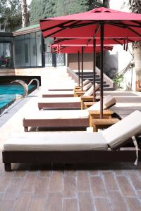 a row of lounge chairs and umbrellas next to a pool at Boris Hotel Istanbul Beylikduzu in Beylikduzu
